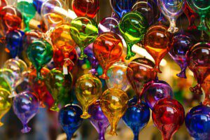 An image of small, glass balloons in a rainbow of colors.