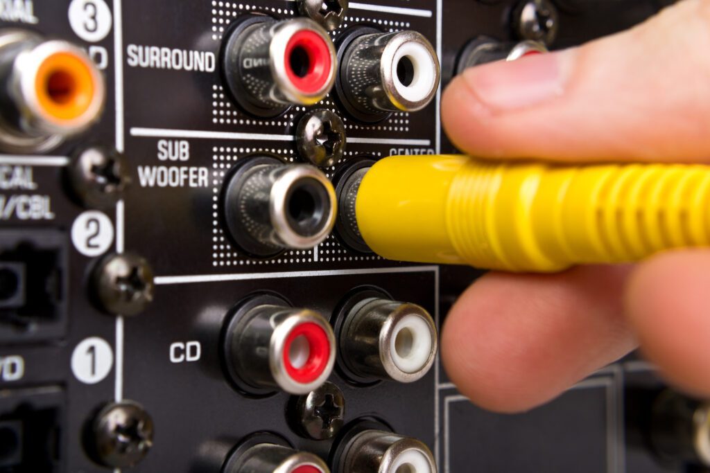 An image of someone plugging in cords to set up AV equipment.
