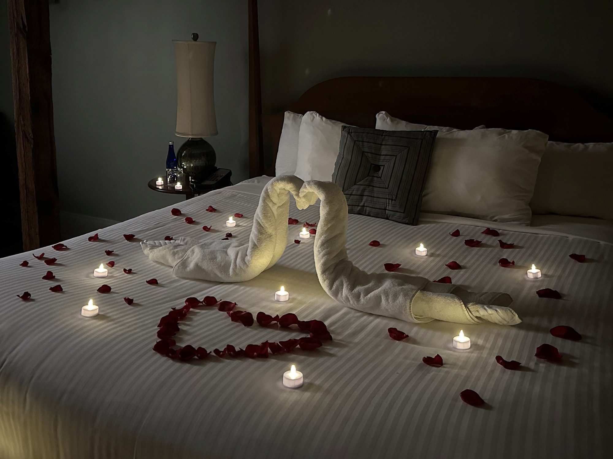 Romance-4 candles and rose petals on a bed